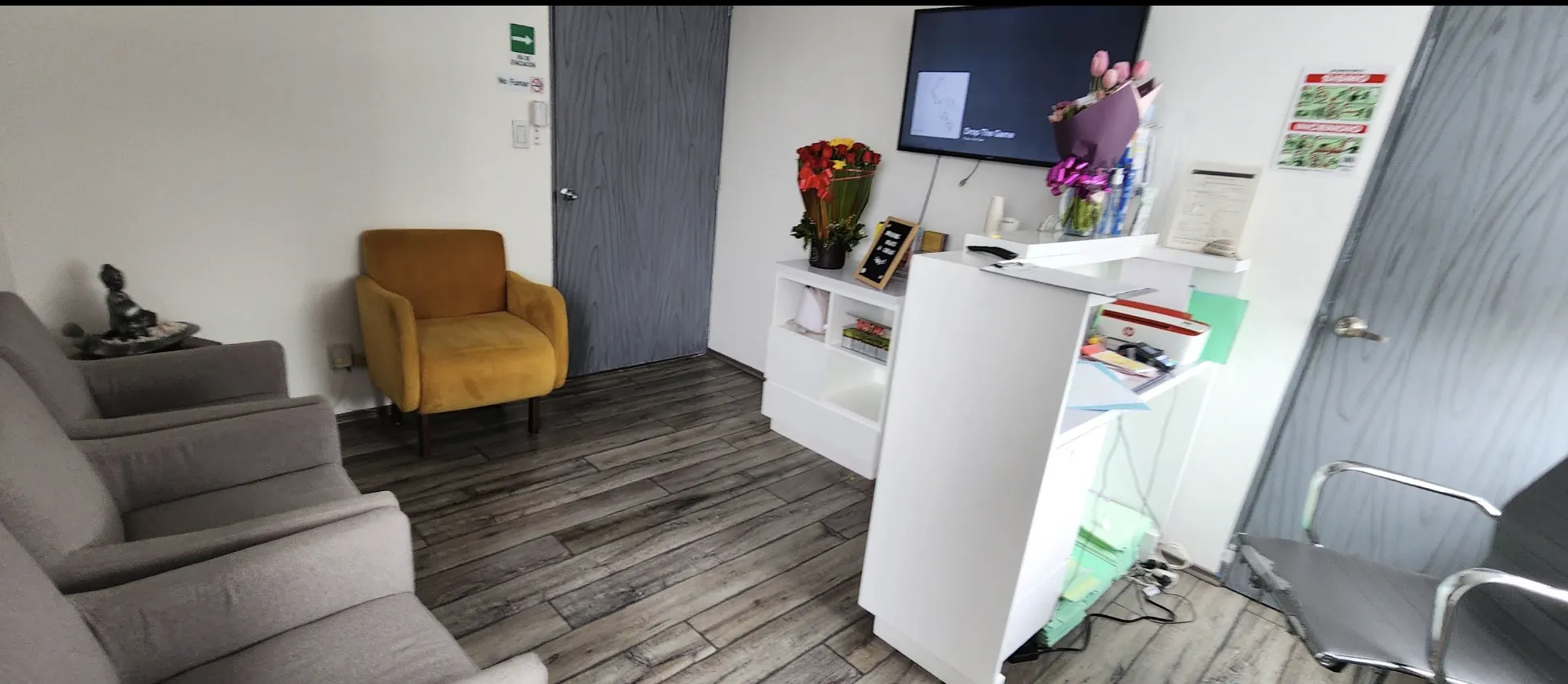 Recepción de Chalet Dental con sillones de espera, mostrador y sillón mostaza