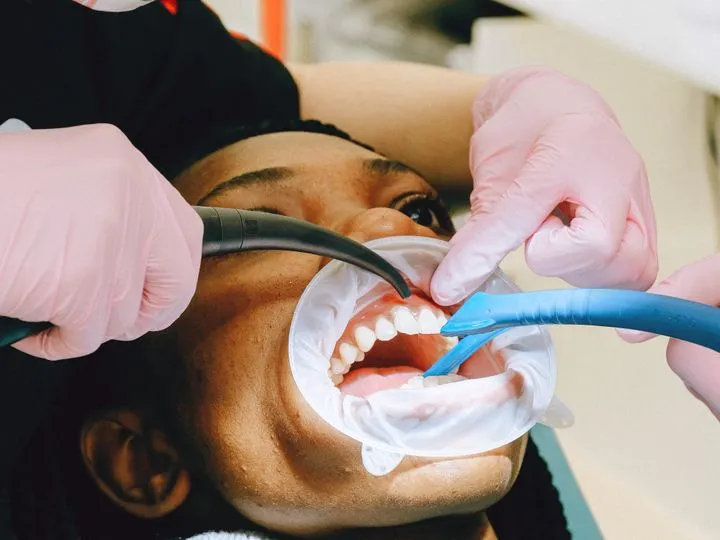 Profesional dental realizando una limpieza y revisión de encías